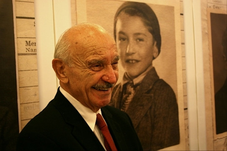 Benny Goren (Grunhut) stands in front of photo of himself as a child at the opening of the Aron Grunhut exhibition in Bratislava. Benny Goren (Grunhut) stands in front of photo of himself as a child at the opening of the Aron Grunhut exhibition in Bratislava.